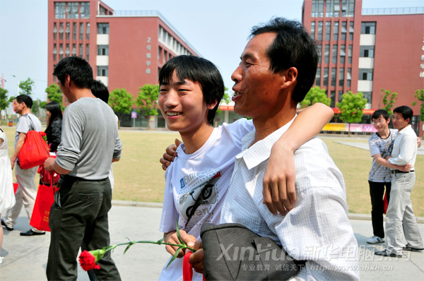 安徽新华电脑专修学院_家长会后的亲子活动:父子二人爽朗地笑着